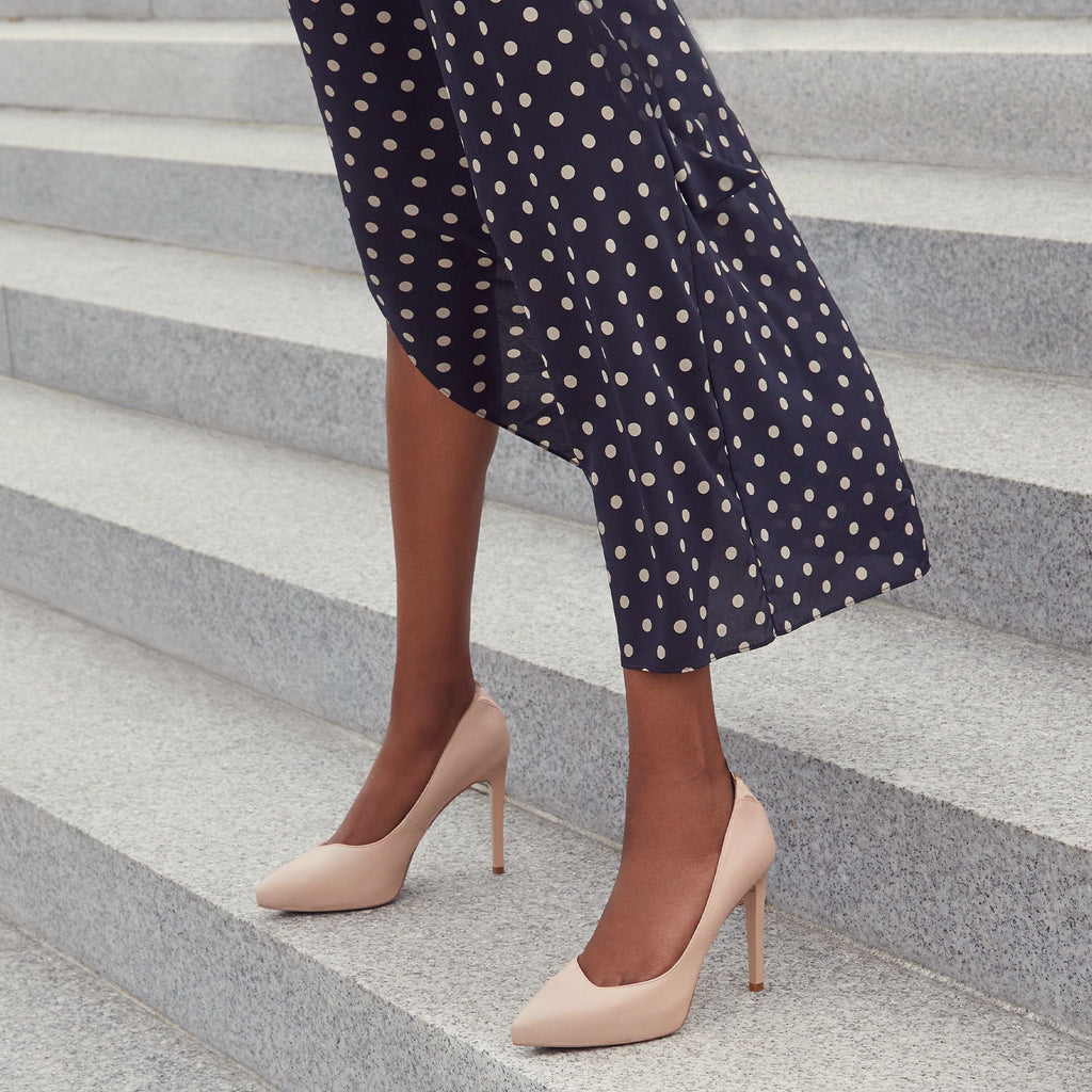 Model wearing a blush pink high-heeled vegan platform pumps with a pointed toe design. Stylish vegan footwear for a chic and sophisticated look.