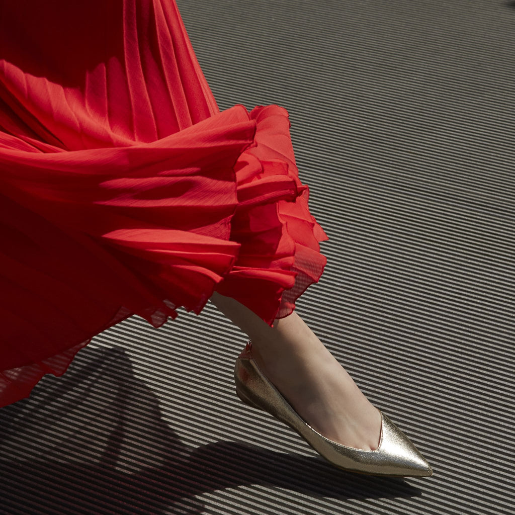 Gold metallic vegan leather pointed-toe ballet flats with an asymmetric v-vamp, cushioned algae-foam insoles and low heel