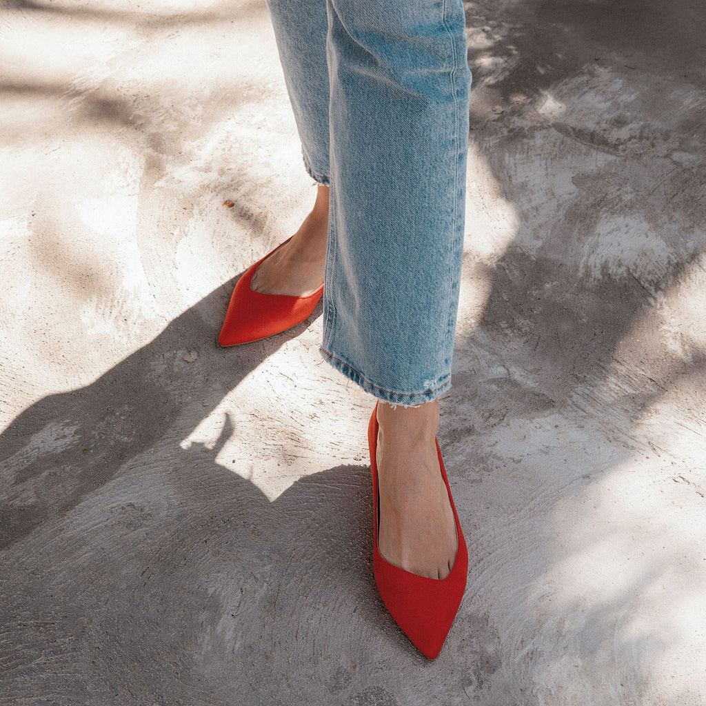 Red vegan faux suede pointed-toe ballet flats with a low heel and asymmetric v-vamp