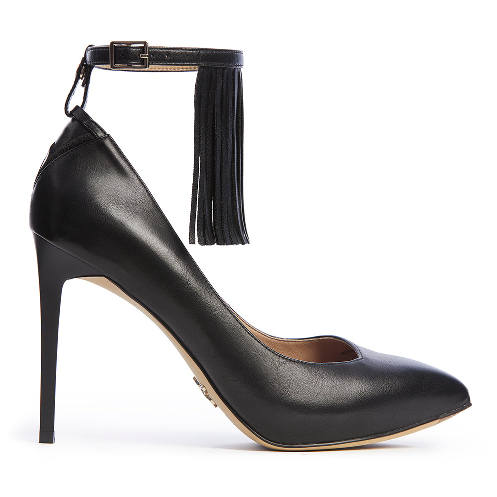 Stylish black high-heeled vegan pumps with ankle strap and fringe detail, perfect for a boho inspired fashion outfit.